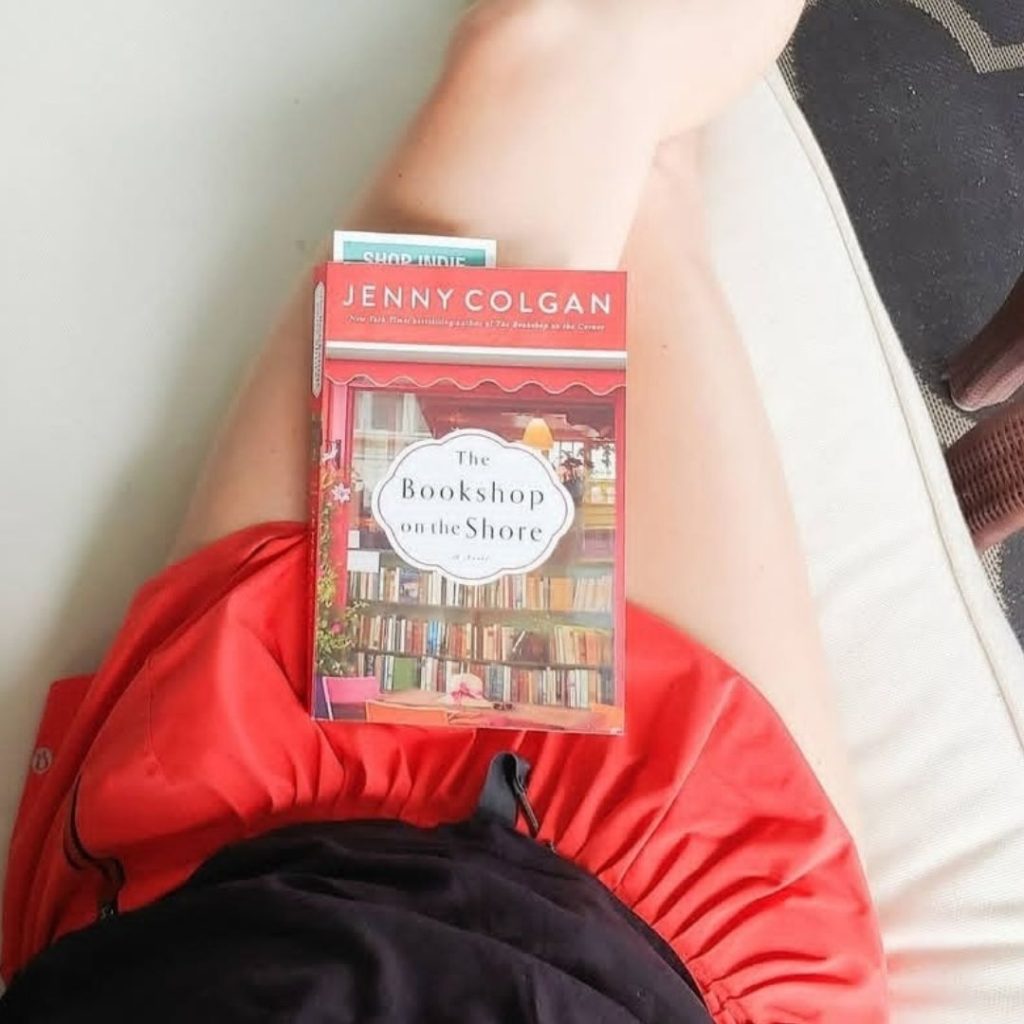 book resting on the legs of someone sitting down