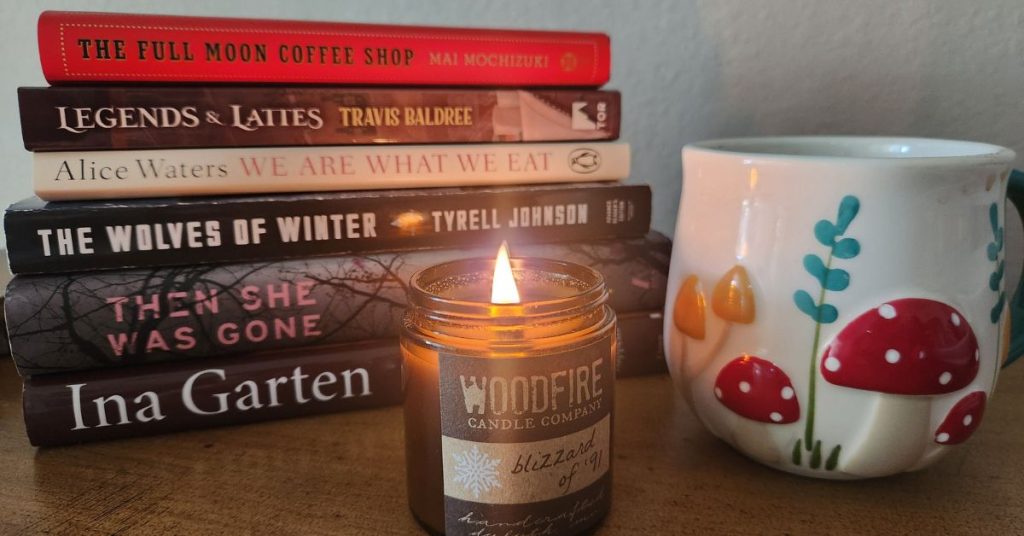 stack of books with coffee cup and candle