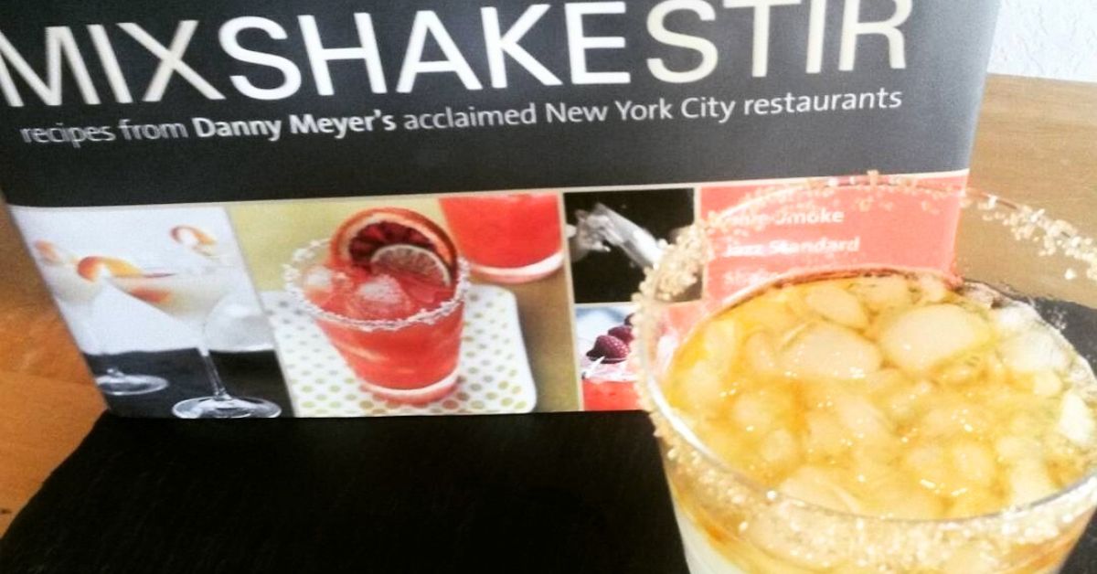 a cocktail book and a drink