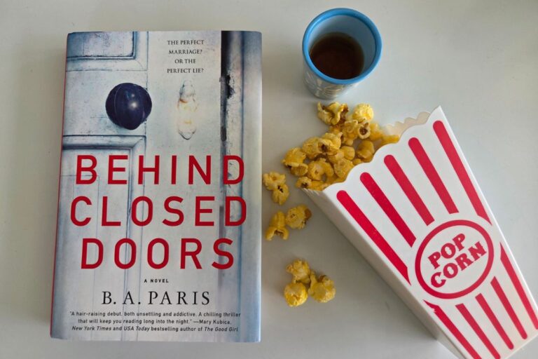 the book Behind Closed Doors with spilled popcorn and a shot of whiskey